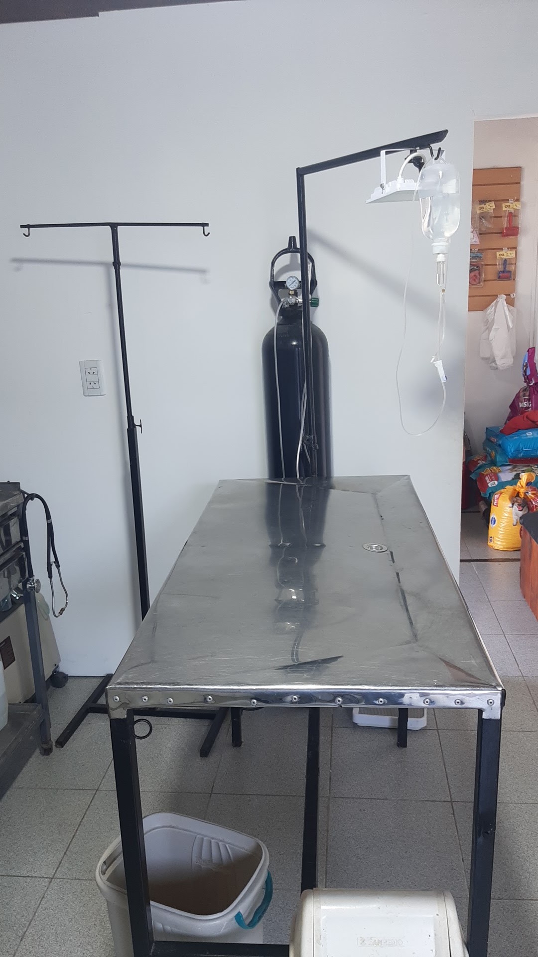 Sala de procedimientos con mesa de acero inoxidable y equipo de oxigenoterapia